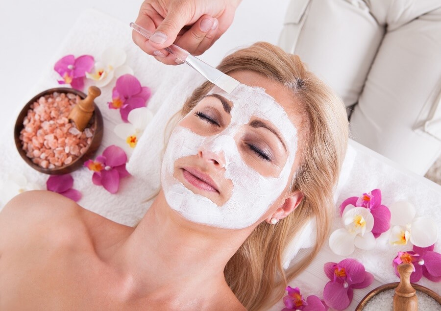 someone applying a face mask on a woman at a spa