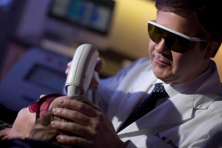 doctor using a laser to lighten a patient's skin