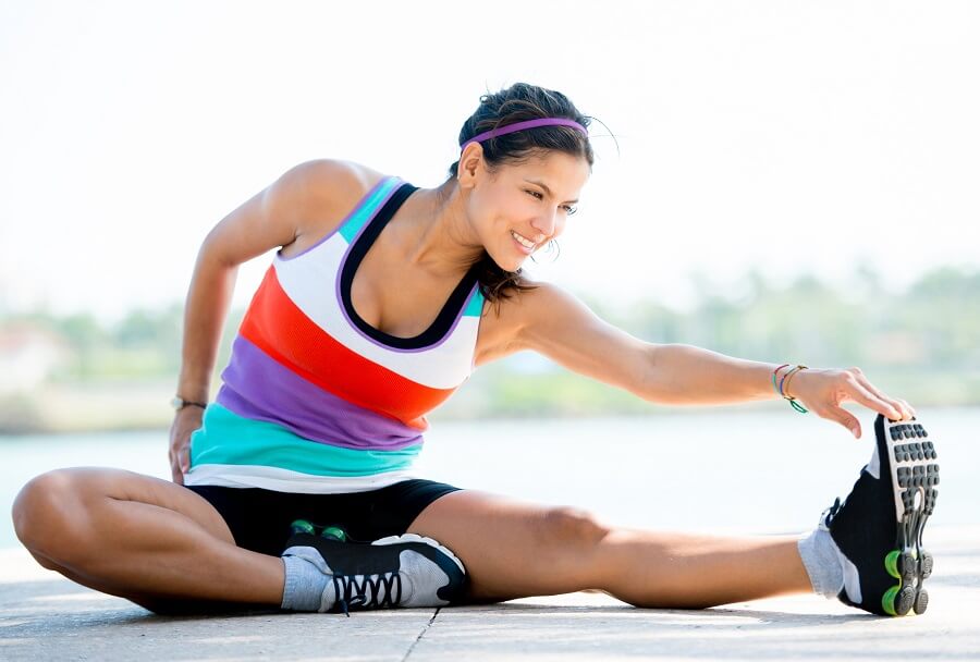 woman smiling while stretching somewhere outside